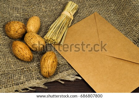 Envelope with straw ball, sackcloth on wodden table.