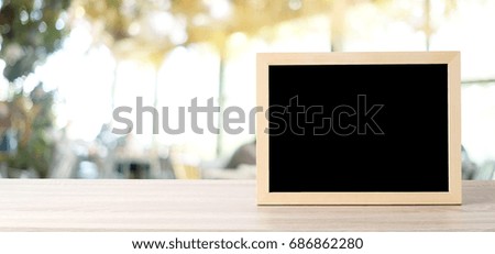 Blank chalkboard standing on wood table over blur restaurant with bokeh background, space for text, mock up, product display montage, banner