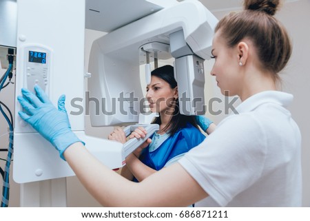 Young woman patient standing in x-ray machine. Panoramic radiography Royalty-Free Stock Photo #686871211