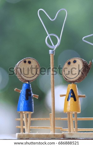 2 wood dolls  and white bokeh on green background