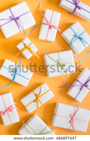 Bright yellow background. Many gifts of different sizes. White gift boxes.