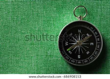 Photo of magnetic compass on a green background. Royalty-Free Stock Photo #686908153