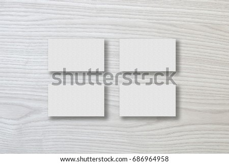 Mockup of four white business cards stacks arranged in rows at white design paper background.