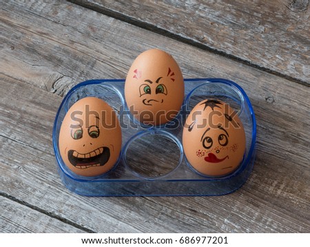  Eggs group in a  box with cheerful and mischievous faces having fun. Concept of joint recreation