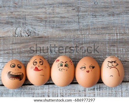 Eggs group in a  box with cheerful and mischievous faces having fun. Concept of joint recreation