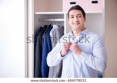 Young man businessman getting dressed for work
