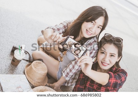 Two happy Asian girl tourist taking photo smile selfie in city. Asia summer travel concept. Beautiful young asian woman travel taking mobile picture with phone together.