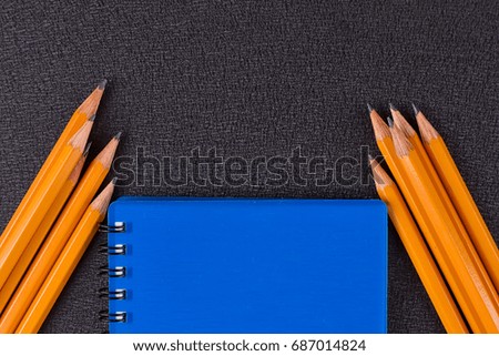 Blank notepad and pencil on black blackground