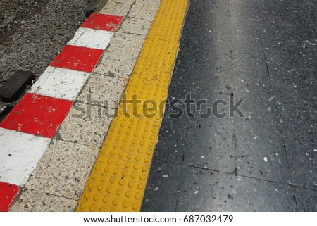 Blind floor tiles with white and red strip warning sign