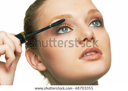 portrait of a young woman using mascara