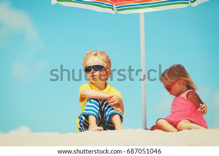 little boy and girl on summer beach