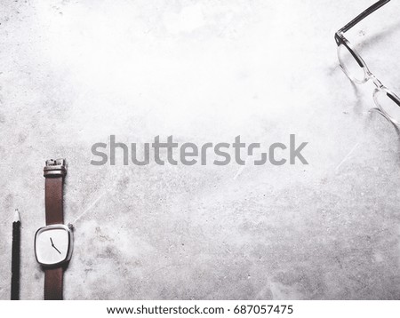 This is office equipment in minimal style, The picture of pencil, glasses and watch on cement background. soft tone color,  minimal style