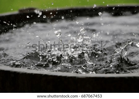 rain is falling in a barrel full of water