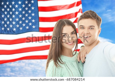 Young couple tacking selfie and USA flag on background