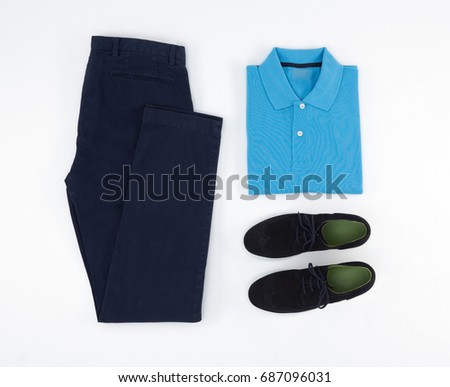 Flat lay set of classic men`s clothes such as blue polo, navy blue trousers and blue classic shoes on white background. Top view.