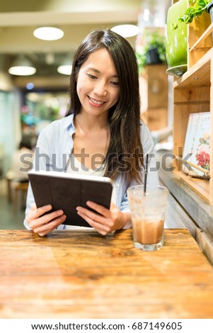 Woman using tablet computer in cafe