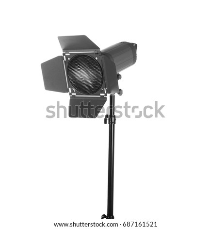 Modern powerful photographic flash. Studio lighting, isolated on the white background. Professional black equipment. Studio photography video light. A long tripod.