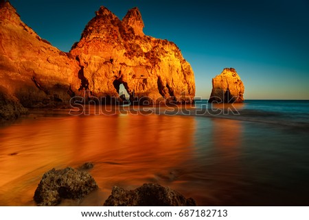 A long exposure, golden hour sunset picture of the Alvor beach in Algarve, Portugal
