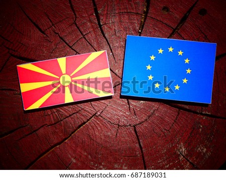 Macedonian flag with EU flag on a tree stump isolated