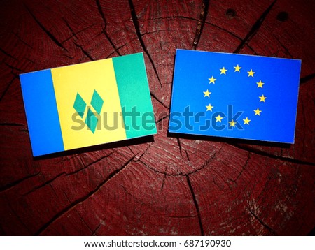 Saint Vincent and the Grenadines flag with EU flag on a tree stump isolated