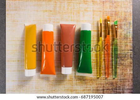 Colours of the nature - mix of green, yellow and brown - home or office interieur design concept, tubes with acrylic paint and  brushes, close up