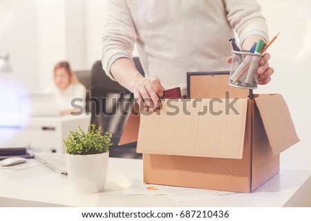 Sad dismissed worker taking his office supplies with him Royalty-Free Stock Photo #687210436