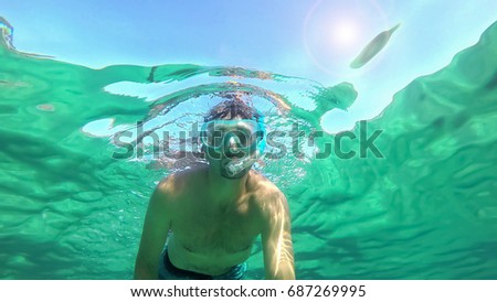 Man snorkeling in Alghero turquoise sea. Sardinia, Italy