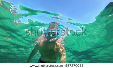 Man snorkeling in Sardinia turquoise water, Italy