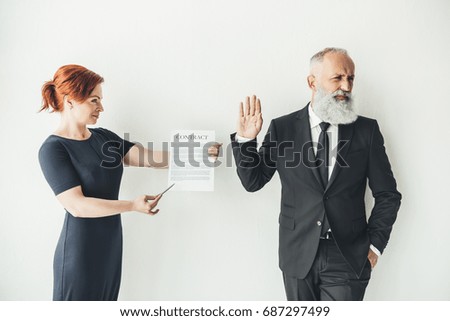 woman holding business contract and businessman refusing to sign it