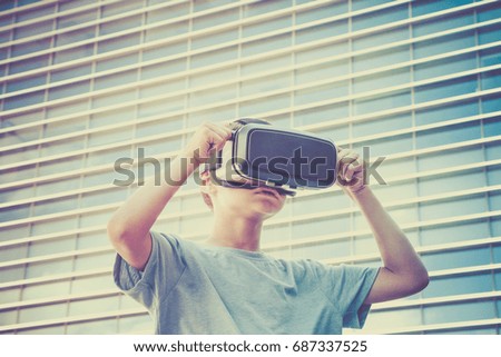 Young boy with virtual reality goggles in the city