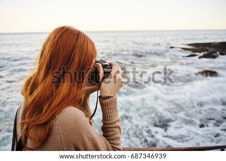 Woman taking pictures of the sea                               