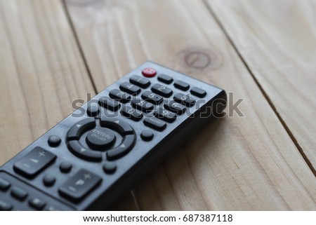 TV remote isolated with wooden table background, selective focus