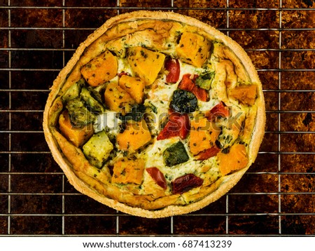 Freshly Baked Vegetable Quiche or Flan Sitting on a Wire Oven Cooling Rack