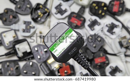 plan view of plugs – Blurred background of  three pin plugs with top of plug  with test sticker Royalty-Free Stock Photo #687419980