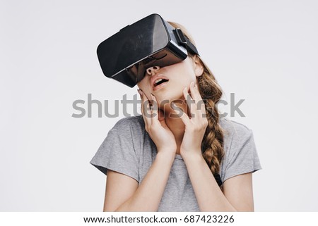 Young beautiful woman on white isolated background with virtual reality glasses, entertainment.