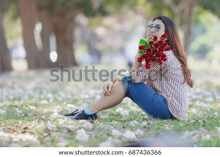 Happy Valentine's day, Beautiful woman holding bouquet rose red flower on daylight in the parks bokeh backgrounds.