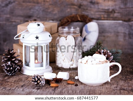 Cocoa with marshmallow and warm knitted plaid on old wooden backgound.   Winter, New Year's still life.