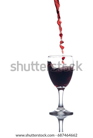 Pouring red water in to a glass on white background