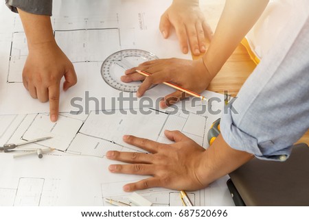 Architect or engineer working on blueprint, architectural concept. Engineer discussing with Architect team meeting and discussing project plan.Engineer discussing with Architect about project