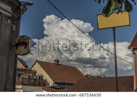Big white clouds over roofs of Prackovice village before storm