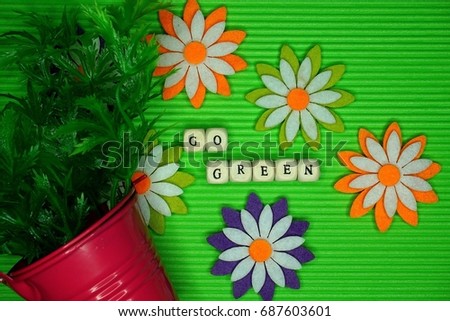 Go Green conceptual photo on the same colored background with flower and vase decoration