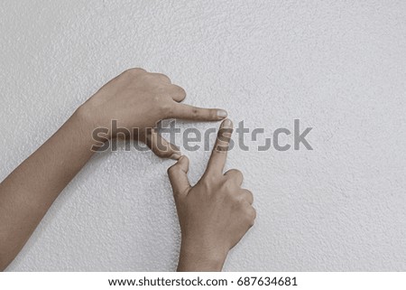 The hands of a girl made heart shape on a white background in the concept of love.
