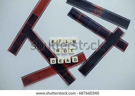 Wording 'Film Not Dead' Film tape roll isolated white background.