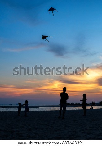 Silhouette of People and Kites at Klebang Beach, Malacca, Malaysia.