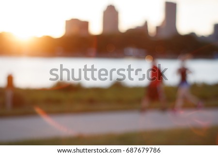 Man and woman running on an urban trail at sunset