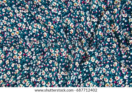 Texture, fabric, background. Cotton flower fabric.  Daisies. Denim floral background. Jeans background with flowers. Blue jeans cloth.
