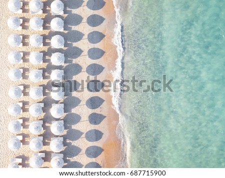 Aerial view of amazing beach with white umbrellas and turquoise sea at sunset. Mediterranean sea, Sardinia, Italy. Royalty-Free Stock Photo #687715900