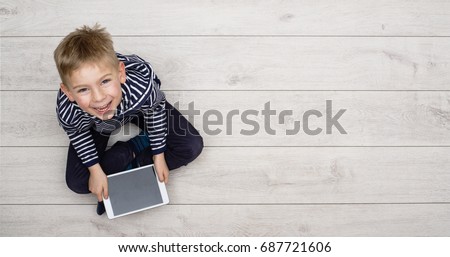 Kid playing with his tablet pc Royalty-Free Stock Photo #687721606