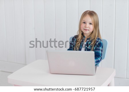 cute little girl studying on laptop at home