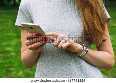 woman, using a smart phone in the hands, outdoors